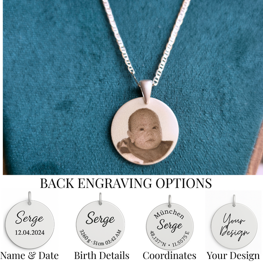 Silver necklace with a round pendant featuring a baby's photo on a teal background.