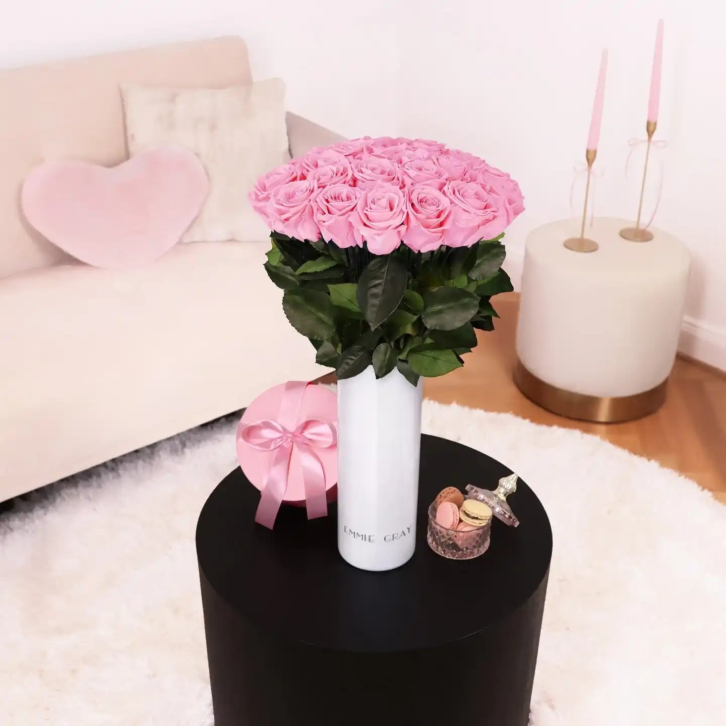 A tall white vase filled with a large bouquet of pink roses.