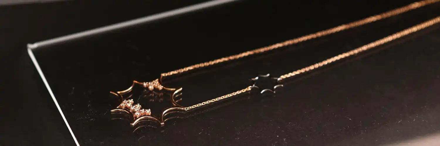 A gold-toned necklace with a star-shaped pendant featuring small, sparkling stones.